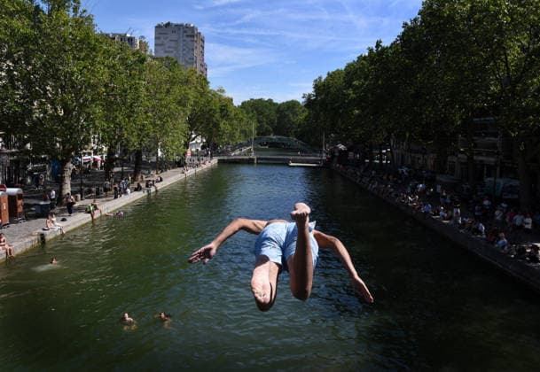 Heatwave Hits at Canal Saint-Martin - Paris Tourists and parisians cool themselves at Canal Saint-Martin as a Heatwave hits in Paris, 40?C expected towards temperature records in France on July 12, 2026. Photo by Alain Apaydin ABACAPRESS.COM Paris France  Copyright: xApaydinxAlain ABACAx