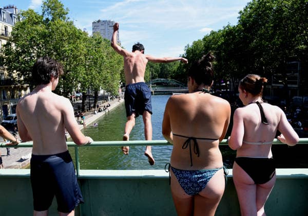 Heatwave Hits at Canal Saint-Martin - Paris Tourists and parisians cool themselves at Canal Saint-Martin as a Heatwave hits in Paris, 40°C expected towards temperature records in France on July 12, 2026. Photo by Alain Apaydin ABACAPRESS.COM Paris France  Copyright: xApaydinxAlain ABACAx