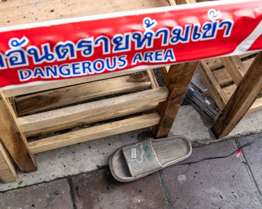 July 13, 2026, Bangkok, Thailand: A close-up of a left shoe with a LUCK label on top, beneath dangerous area warning tape, outside the Rong Beer Na Lat Phrao pub after the fire on Lat Phrao Road in Bangkok. The aftermath of a deadly fire at the Rong Beer Na Lat Phrao pub in Bangkok on 13 July 2026. The blaze killed at least 27 people and injured dozens. Authorities are investigating the cause of the fire. Bangkok Thailand - ZUMAs197 20260713_aaa_s197_015 Copyright: xNathaliexJamoisx