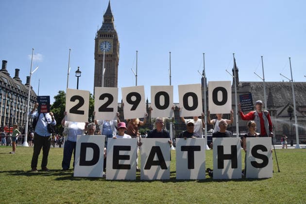 July 13, 2026, London, England, United Kingdom: Activists stage a protest in Parliament Square against the US-UK drug deal. An analysis has suggested that the trade deal could lead to 229,000 excess deaths in England as a result of diverting billions of pounds from essential NHS services to pay for new medicines. London United Kingdom - ZUMAv130 20260713_zip_v130_003 Copyright: xVukxValcicx