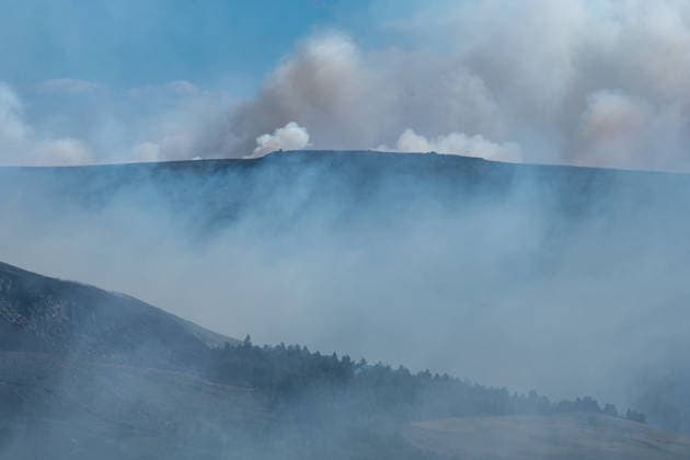 Moorland smoulders close to Dove Stone Reservoir in Greater Manchester on 13 July 2026. Greater Manchester Police have arrested a woman in connection with a large moorland fire at Dove Stone Reservoir in Greenfield. The blaze, burning since Saturday, is under active investigation, with officers following leads regarding reports of fireworks nearby. The 20-year-old suspect remains in custody as the cause of the fire is yet to be officially determined. Oldham Greater Manchester England Dovestone Reservoir  Copyright: xMattxWilkinsonx