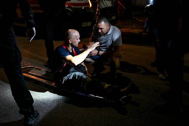 RECORD DATE NOT STATED A man talks to an injured firefighter during emergency response efforts following a nighttime Russian drone attack in Zaporizhzhia, Ukraine, on July 12, 2026. Six people, including a 15-year-old boy, were injured in the attack (Photo by Dmytro Smolienko Ukrinform) Nighttime Russian drone strike hits Zaporizhzhia  Copyright: xDmytroxSmolienkox