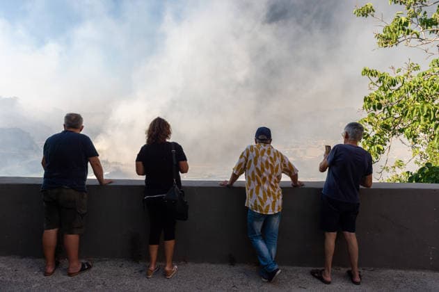 Wildfire erupts near Campi Flegrei volcanic area in Italy POZZUOLI, ITALY - JULY 13: People look at a big wildfire in the Pisciarelli area located on the outer edge of the Solfatara volcanic crater in the Campi Flegrei (Phlegraean Fields) volcanic region in Pozzuoli on July 13, 2026. The fire broke out in the undergrowth and quickly spread to several car dealerships, causing fuel tanks and tyres to explode. Eliano Imperato Anadolu Pozzuoli Italy. Editorial use only. Please get in touch for any other usage.  Copyright: x2026xAnadoluxElianoxImperatox