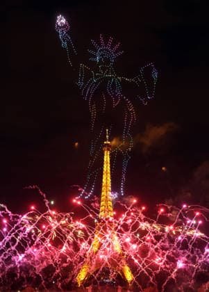Fireworks and drones light the Eiffel Tower during the Bastille Day celebrations in Paris, France, on Monday, July 13, 2026. The municipality brought the event a day earlier so as to dedicate entirely July 14, 2026 to a national tribute marking the 10th anniversary of the Nice attack when 86 people were killed.  PAR20260713103 MAYAxVIDON-WHITE