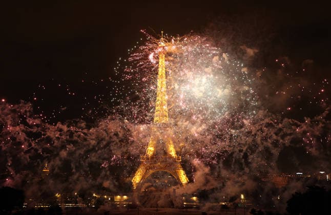 Fireworks and drones light the Eiffel Tower during the Bastille Day celebrations in Paris, France, on Monday, July 13, 2026. The municipality brought the event a day earlier so as to dedicate entirely July 14, 2026 to a national tribute marking the 10th anniversary of the Nice attack when 86 people were killed.  PAR20260713108 MAYAxVIDON-WHITE