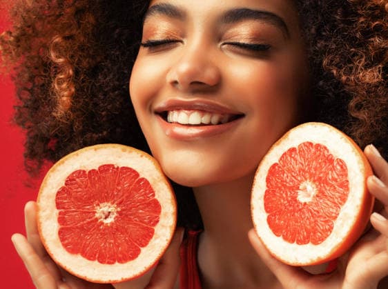 Junge Frau gemischter Herkunft, die in einem kreativen Studio-Porträt Grapefruit-Hälften in den Händen hält Mixed-race woman holding grapefruit halves in a creative studio portrait (License=RF) ,model released, Symbolfoto Copyright: xZoonar.com RaisaxKanarevax 25327809 ,model released, Symbolfoto ,property released