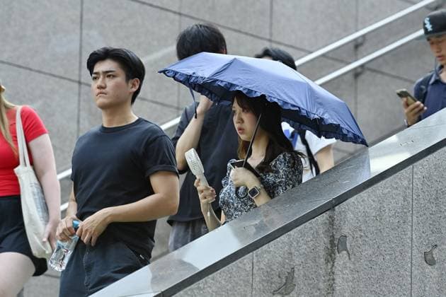 Extreme heat grips Tokyo as temperatures rise across eastern Japan TOKYO, JAPAN - JULY 14 : Pedestrians walk with an umbrella and a hand fan during hot weather in Tokyo, Japan, July 14, 2026. Temperatures in central Tokyo were forecast to reach 34 degrees Celsius. David Mareuil Anadolu Tokyo Japan. Editorial use only. Please get in touch for any other usage.  Copyright: x2026xAnadoluxDavidxMareuilx