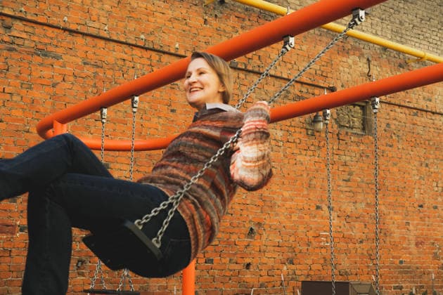 Reife Frau schwingt sich auf der Straße A mature woman in a sweater and jeans swings on a swing on a city street. Joy and fun, the golden age. (License=RF) ,model released, Symbolfoto Copyright: xZoonar.com RaisaxKanarevax 25330409 ,model released, Symbolfoto ,property released