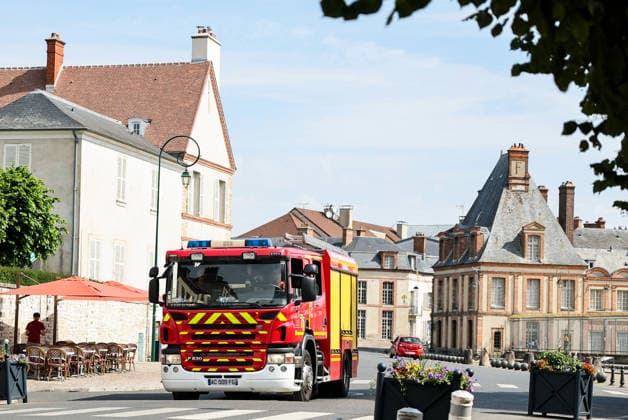 (260714) -- SEINE-ET-MARNE, July 14, 2026 -- A fire truck passes in front of the Palace of Fontainebleau in Seine-et-Marne, France, on July 14, 2026. French police have detained 59 people across the country in connection with wildfires, including two suspects linked to the blaze in the Fontainebleau forest in Seine-et-Marne department, southeast of Paris, French Interior Minister Laurent Nunez said on Monday. The wildfire in the Fontainebleau forest broke out on Sunday evening and continued to spread on Monday. ) FRANCE-SEINE-ET-MARNE-FONTAINEBLEAU-WILDFIRE WuxHuiwo 