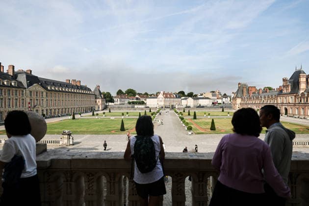 (260714) -- SEINE-ET-MARNE, July 14, 2026 -- Tourists visit the Palace of Fontainebleau in Seine-et-Marne, France, as smoke from a wildfire is seen in the distance, on July 14, 2026. French police have detained 59 people across the country in connection with wildfires, including two suspects linked to the blaze in the Fontainebleau forest in Seine-et-Marne department, southeast of Paris, French Interior Minister Laurent Nunez said on Monday. The wildfire in the Fontainebleau forest broke out on Sunday evening and continued to spread on Monday. ) FRANCE-SEINE-ET-MARNE-FONTAINEBLEAU-WILDFIRE WuxHuiwo 