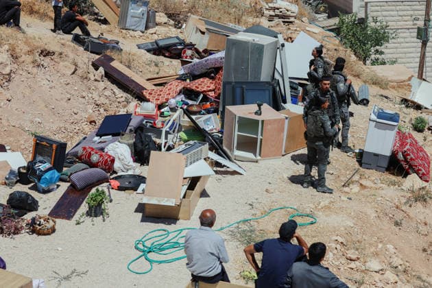 Hebron West Bank Home Demolition Israeli forces stand near household belongings removed from a Palestinian home in Al-Deirat, south of Hebron, occupied West Bank on July 14, 2026. Israeli forces demolish the home of Osama Masaaf on the grounds that it lacked an Israeli-issued building permit, displacing a Palestinian family of eight. Hebron West Bank Palestinian Territories Copyright: xMosabxShawerx
