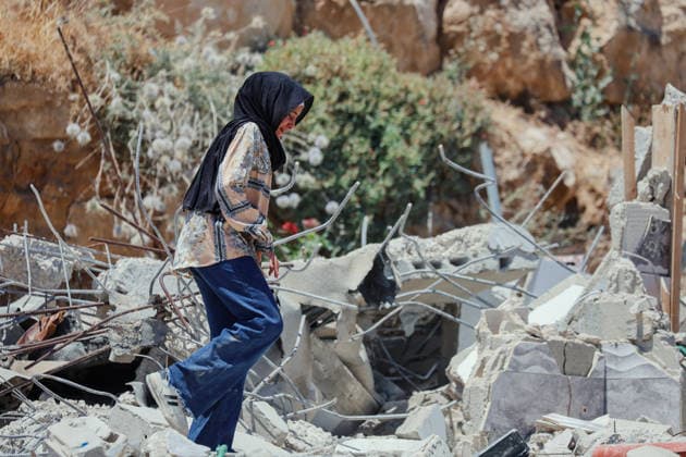 Hebron West Bank Home Demolition A Palestinian woman walks through the rubble of the demolished home of Osama Masaaf s family in Al-Deirat, south of Hebron, occupied West Bank on July 14, 2026. Israeli forces demolish the house on the grounds that it lacked an Israeli-issued building permit, displacing the family of eight. Hebron West Bank Palestinian Territories Copyright: xMosabxShawerx
