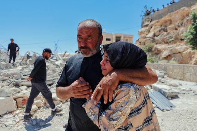 Hebron West Bank Home Demolition A Palestinian man comforts a woman near the rubble of the demolished home of Osama Masaaf s family in Al-Deirat, south of Hebron, occupied West Bank on July 14, 2026. Israeli forces demolish the house on the grounds that it lacked an Israeli-issued building permit, displacing the family of eight. Hebron West Bank Palestinian Territories Copyright: xMosabxShawerx
