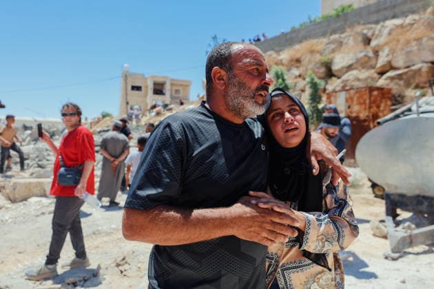 Hebron West Bank Home Demolition A Palestinian man comforts a woman near the rubble of the demolished home of Osama Masaaf s family in Al-Deirat, south of Hebron, occupied West Bank on July 14, 2026. Israeli forces demolish the house on the grounds that it lacked an Israeli-issued building permit, displacing the family of eight. Hebron West Bank Palestinian Territories Copyright: xMosabxShawerx