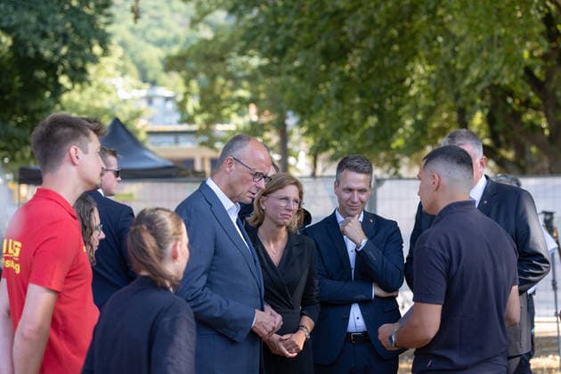 Besuch im Kurpark Bad Neuenahr-Ahrweiler - Fünf Jahre Ahrtalflut Bundeskanzler Friedrich MERZ, Stellvertretende Ministerpräsidentin Rheinland-Pfalz Sabine BÄTZING-LICHTENTHÄLER (SPD), Bürgermeister der Stadt Bad Neuenahr-Ahrweiler Pascal ROWALD (CDU) und Ministerpräsident Gordon SCHNIEDER im Gespräch mit Ehrenamtlichen und Gewerbetreibenden im Kurpark Bad Neuenahr-Ahrweiler. Beim Besuch zum fünften Jahrestag der Flutkatastrophe im Ahrtal informierten sie sich über den Stand des Wiederaufbaus. Bad Neuenahr-Ahrweiler Rheinland-Pfalz Deutschland *** Visit to the Bad Neuenahr Ahrweiler Spa Park: Five Years Since the Ahr Valley Floods. Federal Chancellor Friedrich MERZ; Sabine BÄTZING LICHTENTHÄLER, SPD, Deputy Minister-President of Rh Copyright: xMarcxJohnx