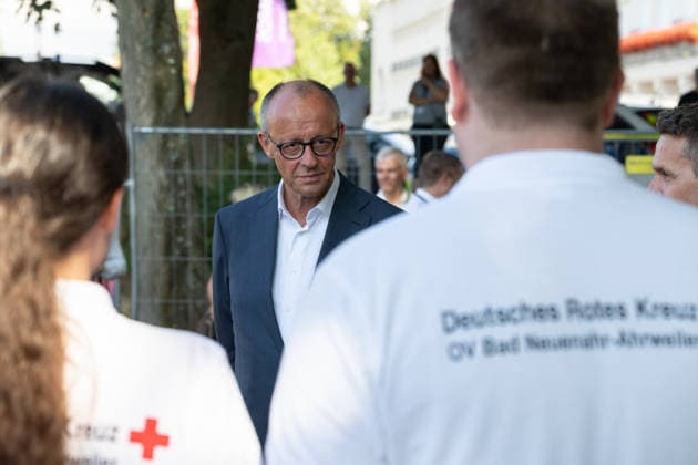 Besuch im Kurpark Bad Neuenahr-Ahrweiler - Fünf Jahre Ahrtalflut Bundeskanzler Friedrich MERZ im Gespräch mit Ehrenamtlichen und Gewerbetreibenden im Kurpark Bad Neuenahr-Ahrweiler. Beim Besuch zum fünften Jahrestag der Flutkatastrophe im Ahrtal informierten sie sich über den Stand des Wiederaufbaus. Bad Neuenahr-Ahrweiler Rheinland-Pfalz Deutschland *** Visit to the Spa Park in Bad Neuenahr-Ahrweiler: Five Years Since the Ahr Valley Floods. Federal Chancellor Friedrich MERZ in conversation with volunteers and business owners at the Spa Park in Bad Neuenahr-Ahrweiler. During his visit to mark the fifth anniversary of the flood disaster in the Ahr Valley, he was briefed on the status of the reconstruction efforts in Bad Neuenahr-Ahrweil Copyright: xMarcxJohnx