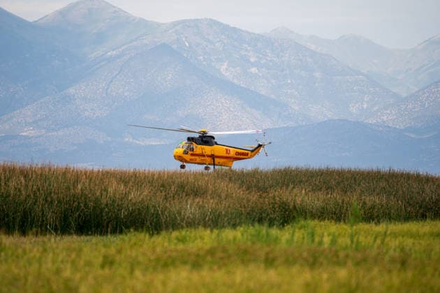 July 14, 2026, Vernon, Utah, USA: A firefighting helicopter flies low over the landscape after drawing water from Atherley Reservoir near Vernon, Utah, on Tuesday, July 14, 2026. Aerial units are maintaining a continuous rotation to drop water on active hot spots along the Stookey wildfire perimeter in Tooele County. Vernon USA - ZUMAm292 20260714_znp_m292_005 Copyright: xCharlesxMcClintockxWilsonx