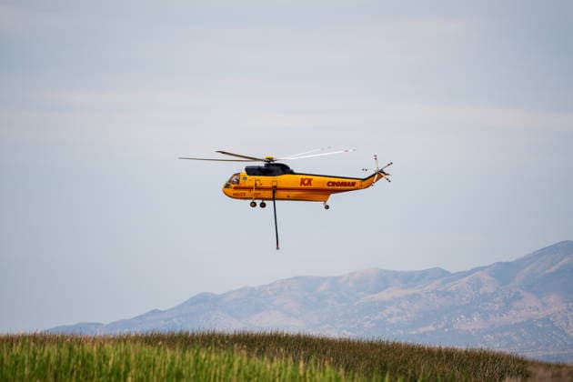 July 14, 2026, Vernon, Utah, USA: A firefighting helicopter flies low over the landscape after drawing water from Atherley Reservoir near Vernon, Utah, on Tuesday, July 14, 2026. Aerial units are maintaining a continuous rotation to drop water on active hot spots along the Stookey wildfire perimeter in Tooele County. Vernon USA - ZUMAm292 20260714_znp_m292_012 Copyright: xCharlesxMcClintockxWilsonx