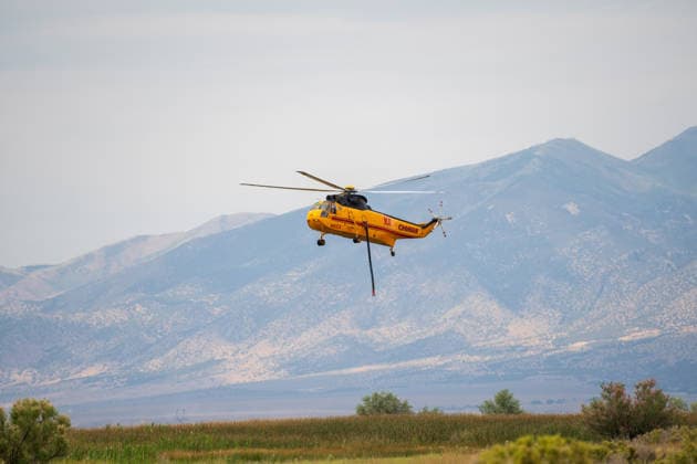 July 14, 2026, Vernon, Utah, USA: A firefighting helicopter hovers above Atherley Reservoir to draw water near Vernon, Utah, on Tuesday, July 14, 2026. Aerial units are tapping local reservoirs to suppress active hot spots on the aggressive Stookey wildfire in Tooele County. Vernon USA - ZUMAm292 20260714_znp_m292_020 Copyright: xCharlesxMcClintockxWilsonx