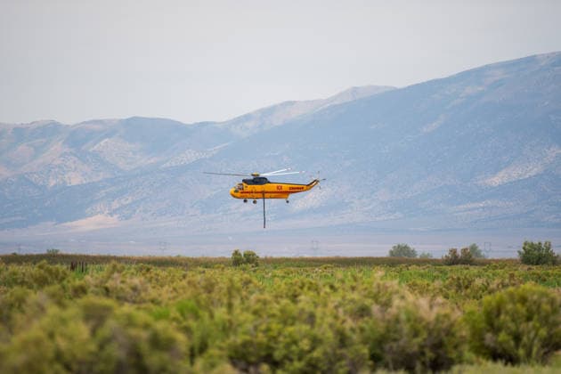 July 14, 2026, Vernon, Utah, USA: A firefighting helicopter hovers above Atherley Reservoir to draw water near Vernon, Utah, on Tuesday, July 14, 2026. Aerial units are tapping local reservoirs to suppress active hot spots on the aggressive Stookey wildfire in Tooele County. Vernon USA - ZUMAm292 20260714_znp_m292_021 Copyright: xCharlesxMcClintockxWilsonx