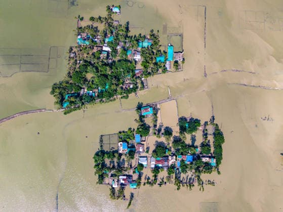Aftermath Of Floodwaters In Chattogram A high-angle top-down drone shot displays scattered rural clusters submerged under murky floodwaters following heavy monsoon rains in Banshkhali, Chattogram, Bangladesh, on July 14, 2026. Flood waters in Banshkhali and Satkania in Chittagong are slowly receding, revealing collapsed mud houses, damaged structures, destroyed brick kilns and severely damaged agricultural land. The flooding has displaced thousands of people. Chattogram Bangladesh  Copyright: xZakirxHossainx originalFilename: hossain-notitle260714_npzvX.jpg
