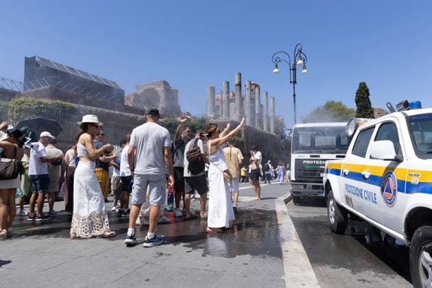 IPA86702512 - Tourists seek relief from the heat under the misting spray in front of the Colosseum in Rome  Copyright: xMatteoxNardonex xx 86702512