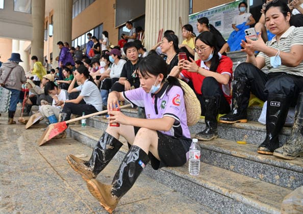 (260715) -- NANNING, July 15, 2026 -- People take a break during the clearing work at a middle school in Guigang City, south China s Guangxi Zhuang Autonomous Region, July 15, 2026. Efforts are underway to facilitate flood relief and recovery in Guangxi, which has been hit by severe rainstorms and flooding caused by Typhoon Maysak. ) CHINA-GUANGXI-TYPHOON MAYSAK-AFTERMATH-RECOVERY (CN) LuxBoan 