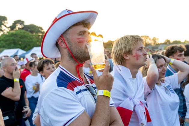 Public Viewing England - Argentinien in Torquay Torquay, England- 15.7.2026: Fußballfans aus Torquay reagieren während der ersten Halbzeit des Fussballspiels England gegen Argentinien bei der WM 2026 bei einem Public Viewing am Hafen von Torquay. England steht im Halbfinale der Weltmeisterschaft 2026 gegen Argentinien und kann zum zweiten Mal in seiner Geschichte nach 1966 Weltmeister im Männerfußball werden England