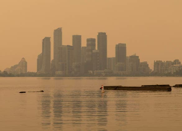 (260716) -- BEIJING, July 16, 2026 -- Wildfire smoke from northwestern Ontario fills the sky in Toronto, Canada, on July 15, 2026. Wildfires sweeping across northwestern Ontario, Canada, in recent days have caused severe smog and a sharp deterioration in air quality in several regions, including Ottawa, the nation s capital, and Toronto, Canada s largest city. (Photo by Zou Zheng Xinhua) XINHUA PHOTOS OF THE DAY LinxWei 