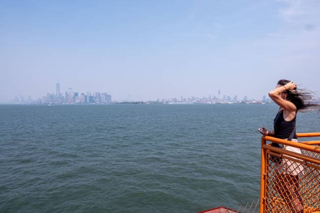 July 15, 2026, New York, New York, USA: A woman takes in the hazy view of the Manhattan Skyline from the Staten Island Ferry as smoke from the Canadian wildfires moves over the city...Both heat and Air Quality Health Advisories are in effect New York City as smoke from Canadian wildfires coincide with temperatures expected to reach near100Ã‚Â°F as a heatwave continues. New York USA  - ZUMAp288 20260715_znp_p288_028 Copyright: xSyndixPilarx
