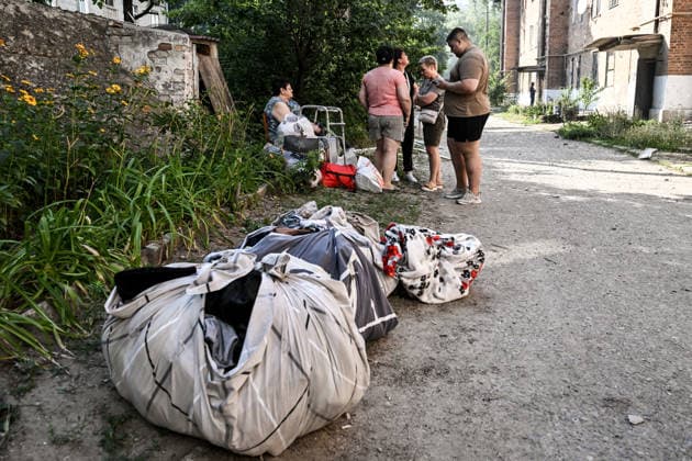 Bundles with belongings lie on the ground near residents evacuated from a three-storey apartment block damaged by a Russian airstrike due to the threat of collapse, Zaporizhzhia, Ukraine, July 15, 2026. The Russian army attacked the southeastern city with guided aerial bombs, killing three people and injuring at least 15 others. The strikes also damaged critical and civilian infrastructure. (Photo by Dmytro Smolienko Ukrinform) Russia launches another air strike on Zaporizhzhia  Copyright: xDmytroxSmolienkox