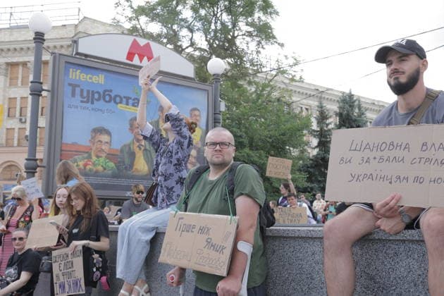 Anti-War Protesters Gather - Kharkiv Protesters holding handmade signs with Ukrainian text gather on Freedom Square in Kharkiv on July 16, 2026, opposing the dismissal of Mikhail Fedorov. Approximately 500 young people assembled in the city center, with some standing on a monument base holding cardboard placards with messages in Ukrainian. A lifecell advertisement billboard is visible in the background along with neoclassical government buildings. Photo by Titov Yevhen ABACAPRESS.COM Kharkiv Kharkiv Oblast Ukraine  Copyright: xTitovxYevhen ABACAx