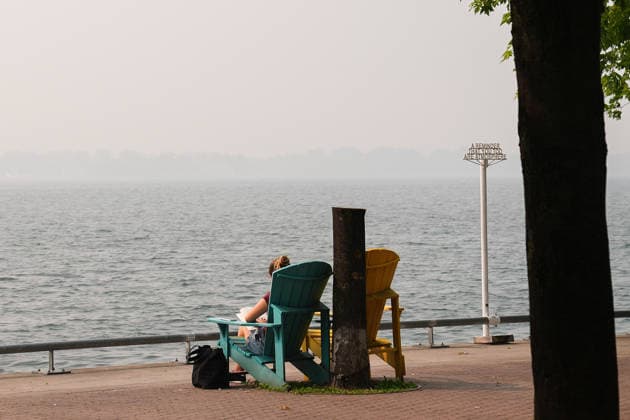 Forest Fires Smoke Blankets Toronto TORONTO, CANADA - JULY 16 : A person reads a book along Lake Ontario as smoke from wildfires continue to impact air quality in Toronto, Ontario on July 16, 2026. Smoke from wildfires in northwestern Ontario has moved into parts of the province, causing very poor air quality and reduced visibility, prompting Environment Canada to issue a high-level air quality alert Wednesday. Mert Alper Dervis Anadolu Ontario Canada. Editorial use only. Please get in touch for any other usage.  Copyright: x2026xAnadoluxMertxAlperxDervisx