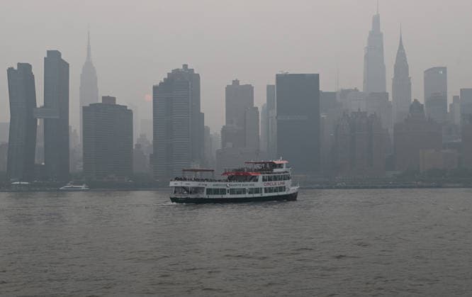 July 16, 2026, New York, New York, USA: July 16, 2026 - New York, NY, USA - New York City midtown skyline with the Empire State Building seen across the East River is masked by smoke coming from the ongoing Canadian wildfires. New Yorkers out with their families, friends, and pets go about their lives as they navigate the smoked filled air. (Andrea RENAULT Zuma Press) New York USA - ZUMAg115 20260716_faf_g115_046 Copyright: xAndreaxRenaultx