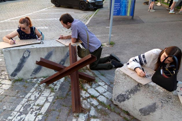 Demonstrators write slogans on the pieces of cardboard on concrete blocks near an anti-tank obstacle, known as a Czech hedgehog, during a protest action against the dismissal of Ukrainian Defence Minister Mykhailo Fedorov in Ivana Franka Square in the evening on the second day of rallies, Kyiv, Ukraine, July 17, 2026. (Photo by Kyrylo Chubotin Ukrinform) Protest action against dismissal of Mykhailo Fedorov goes on in Kyiv  Copyright: xKyryloxChubotinx