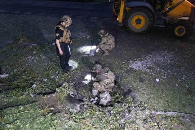 July 17, 2026, Kharkiv, Kharkiv Oblast, ukraine: Military personnel and emergency responders conduct damage assessment at a site struck by russian Banderol missile attack in Shevchenkivskyi District, Kharkiv, Ukraine, July 17, 2026. One 40-year-old man was killed in his vehicle during the strike; seven others were hospitalized with injuries. Debris and destroyed equipment scattered across the ground vegetation near a yellow construction vehicle at the scene. Kharkiv ukraine  - ZUMAt164 20260717_zip_t164_020 Copyright: xYevhenxTitovx