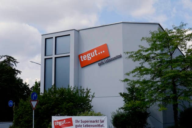 tegut store in Munich tegut store in Munich Exterior view of the supermarket featuring the company logo and an advertising poster RECORD DATE NOT STATED