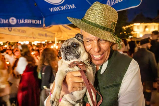 Kocherlball am Chinesischen Turm, Biertrinken bei Kerzenschein um 4:10 Uhr, Besucher mit seinem Mops, München, 19. Juli 2026 Deutschland, München, 19. Juli 2026, Biertrinken bei Kerzenschein um 4:10 Uhr, traditioneller Kocherlball am Chinesischen Turm, Englischer Garten, der Münchner Hans ist mit seinem Mops da, manche Besucher rsind schon um 3 Uhr früh im Biergarten, um noch einen Platz zu ergattern, die Menschen trinken ein Bier, essen eine Brotzeit, tragen Tracht, Tradition entstand im 19. Jahrhundert, als Hauspersonal, Dienstboten und KöchInnen in den frühen Morgenstunden vor Dienstbeginn gefeiert und getanzt haben, Tradition wurde ab 1989 wiederbelebt, traditionell am 3. Sonntag im Juli, feiern, Tradition, traditionell, Bayern, t