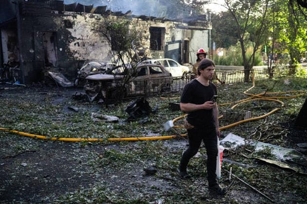 A man walks past a firefighter working at a five-storey apartment block in the Solomianskyi district damaged by a Russian attack on Kyiv, Ukraine, July 19, 2026. The Russian army launched a massive strike on the Ukrainian capital with ballistic missiles. According to preliminary data from the State Emergency Service of Ukraine, one person was killed and 15 were injured. Falling debris and fires were reported in five districts of the city, while an underpass near the Lukianivska metro station sustained a direct hit. (Photo by Danylo Antoniuk Ukrinform) Russian army attack Kyiv with ballistic missiles  Copyright: xDanyloxAntoniukx