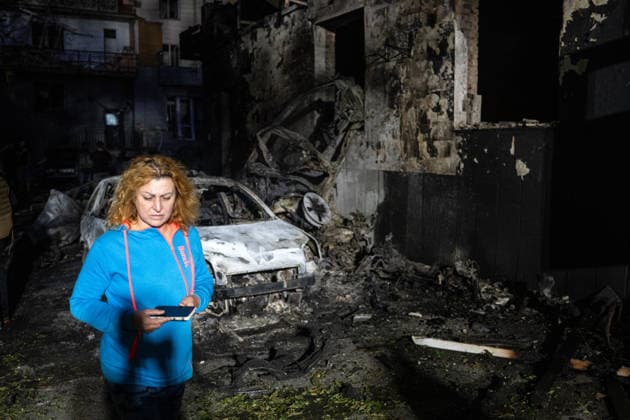 A woman walks past a burnt-out car and a building in the Solomianskyi district after a Russian attack on Kyiv, Ukraine, July 19, 2026. The Russian army launched a massive strike on the Ukrainian capital with ballistic missiles. According to preliminary data from the State Emergency Service of Ukraine, one person was killed and 15 were injured. Falling debris and fires were reported in five districts of the city, while an underpass near the Lukianivska metro station sustained a direct hit. (Photo by Danylo Antoniuk Ukrinform) Russian army attacks Kyiv with ballistic missiles  Copyright: xDanyloxAntoniukx
