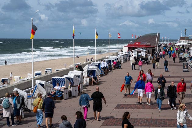 Sommer in Westerland auf Sylt 19.07.2026, Westerland --- Besucher flanieren entlang der Strandpromenade am Hauptstrand von Westerland auf Sylt. Strandkörbe und Flaggen säumen den Nordseestrand. Westerland Schleswig-Holstein Deutschland *** Summer in Westerland on Sylt, July 19, 2026. Visitors in Westerland stroll along the beach promenade on Westerland’s main beach on Sylt. Beach chairs and flags line the North Sea beach in Westerland, Schleswig-Holstein, Germany.
