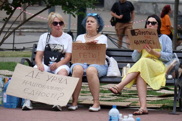 Three women with placards sit on the bench during a protest action against the dismissal of Ukrainian Defence Minister Mykhailo Fedorov in Ivana Franka Square outside the Ivan Franko National Academic Drama Theatre and near the Office of the President, Kyiv, Ukraine, July 19, 2026. (Photo by Pavlo Bahmut Ukrinform) Day Four of protest action against dismissal of Mykhailo Fedorov in Kyiv  Copyright: xPavloxBahmutx