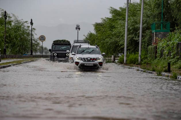 July 20, 2026, Srinagar, Jammu And Kashmir, India: People travel with their vehicles through a waterlogged road during heavy rainfall in Srinagar.Torrential rain unleashed flash floods and landslides in Pir Panjal region of J&Ks Poonch and Rajouri districts Sunday, killing at least 14 people, leaving several missing and burying homes under walls of water, rock and mud that barrelled down mountain slopes. Officials said the toll could rise as rescuers searched for those trapped beneath debris. Srinagar India  - ZUMAz120 20260720_zip_z120_002 Copyright: xBasitxZargarx