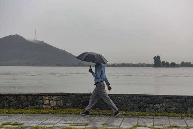 July 20, 2026, Srinagar, Jammu And Kashmir, India: A man walks during heavy rainfall in Srinagar.Torrential rain unleashed flash floods and landslides in Pir Panjal region of J&Ks Poonch and Rajouri districts Sunday, killing at least 14 people, leaving several missing and burying homes under walls of water, rock and mud that barrelled down mountain slopes. Officials said the toll could rise as rescuers searched for those trapped beneath debris. Srinagar India - ZUMAz120 20260720_zip_z120_006 Copyright: xBasitxZargarx