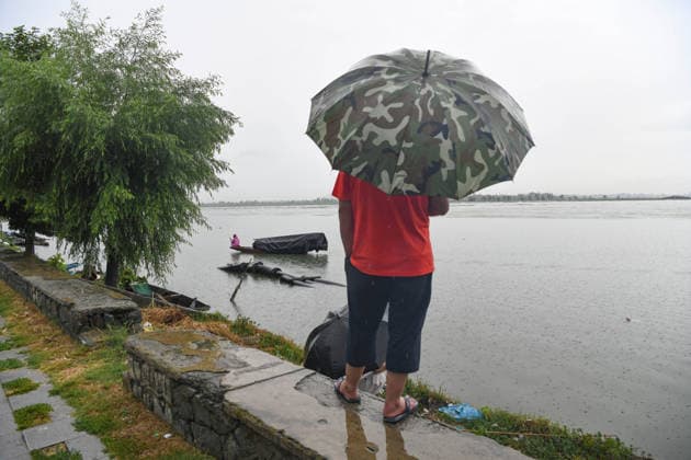 July 20, 2026, Srinagar, Jammu And Kashmir, India: A fisherman rows his boat during heavy rainfall in Srinagar.Torrential rain unleashed flash floods and landslides in Pir Panjal region of J&Ks Poonch and Rajouri districts Sunday, killing at least 14 people, leaving several missing and burying homes under walls of water, rock and mud that barrelled down mountain slopes. Officials said the toll could rise as rescuers searched for those trapped beneath debris. Srinagar India  - ZUMAz120 20260720_zip_z120_005 Copyright: xBasitxZargarx