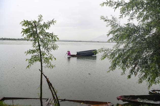 July 20, 2026, Srinagar, Jammu And Kashmir, India: A fisherman rows his boat during heavy rainfall in Srinagar.Torrential rain unleashed flash floods and landslides in Pir Panjal region of J&Ks Poonch and Rajouri districts Sunday, killing at least 14 people, leaving several missing and burying homes under walls of water, rock and mud that barrelled down mountain slopes. Officials said the toll could rise as rescuers searched for those trapped beneath debris. Srinagar India - ZUMAz120 20260720_zip_z120_007 Copyright: xBasitxZargarx