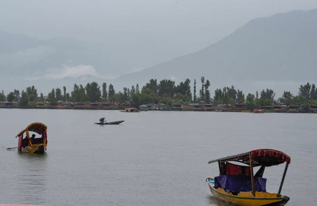 July 20, 2026, Srinagar, Jammu And Kashmir, India: Boatmen row their Shikara boats during heavy rainfall in Srinagar.Torrential rain unleashed flash floods and landslides in Pir Panjal region of J&Ks Poonch and Rajouri districts Sunday, killing at least 14 people, leaving several missing and burying homes under walls of water, rock and mud that barrelled down mountain slopes. Officials said the toll could rise as rescuers searched for those trapped beneath debris. Srinagar India  - ZUMAz120 20260720_zip_z120_014 Copyright: xBasitxZargarx