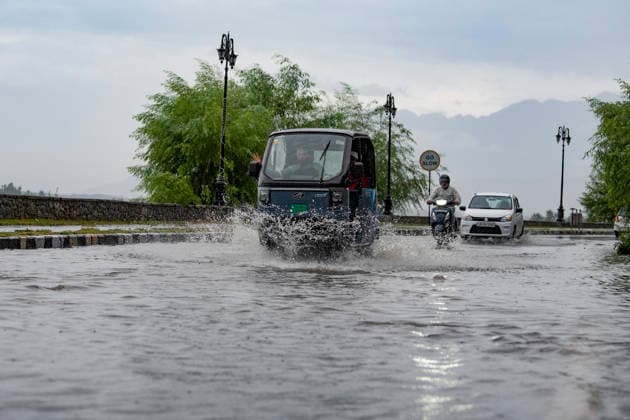 July 20, 2026, Srinagar, Jammu And Kashmir, India: People travel with their vehicles through a waterlogged road during heavy rainfall in Srinagar.Torrential rain unleashed flash floods and landslides in Pir Panjal region of J&Ks Poonch and Rajouri districts Sunday, killing at least 14 people, leaving several missing and burying homes under walls of water, rock and mud that barrelled down mountain slopes. Officials said the toll could rise as rescuers searched for those trapped beneath debris. Srinagar India - ZUMAz120 20260720_zip_z120_017 Copyright: xBasitxZargarx