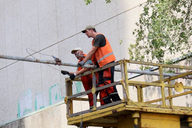 Municipal workers standing on an aerial work platform deal with the consequences of a large-scale overnight Russian missile attack in the Shevchenkivskyi district, Kyiv, Ukraine, July 19, 2026. The Russian army launched a massive attack on the capital with ballistic missiles. According to the State Emergency Service of Ukraine, an 89-year-old woman was killed and 15 people were injured. Falling debris and fires were reported in five districts of the city, while a direct hit was recorded at the underpass near Lukianivska metro station. (Photo by Pavlo Bahmut Ukrinform) Russian missile hits underground passage near Lukianivska metro station in Kyiv  Copyright: xPavloxBahmutx