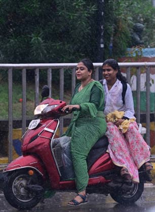 July 20, 2026, Prayagraj, Uttar Pradesh, India: Prayagraj: Women ride scotty during Rain, in Prayagraj on Monday, July 20, 2026. Prayagraj India - ZUMAv115 20260720_zap_v115_054 Copyright: xPrabhatxKumarxVermax